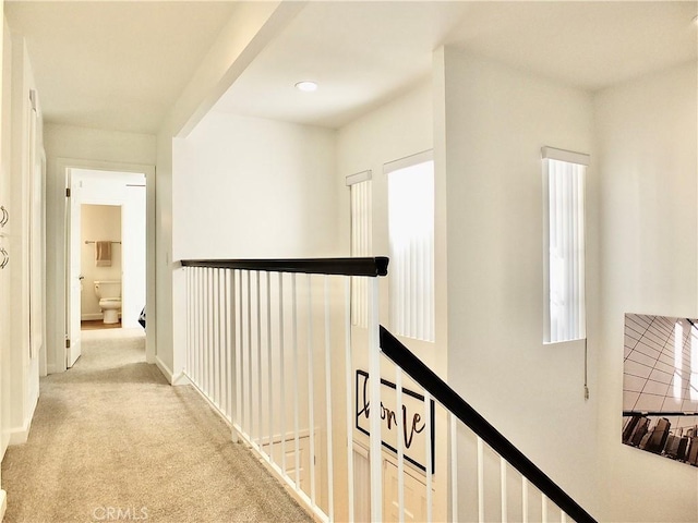 hallway featuring light colored carpet