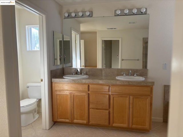 bathroom featuring vanity, tile patterned floors, and toilet