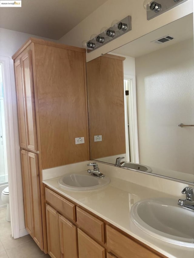 bathroom featuring vanity, tile patterned floors, and toilet