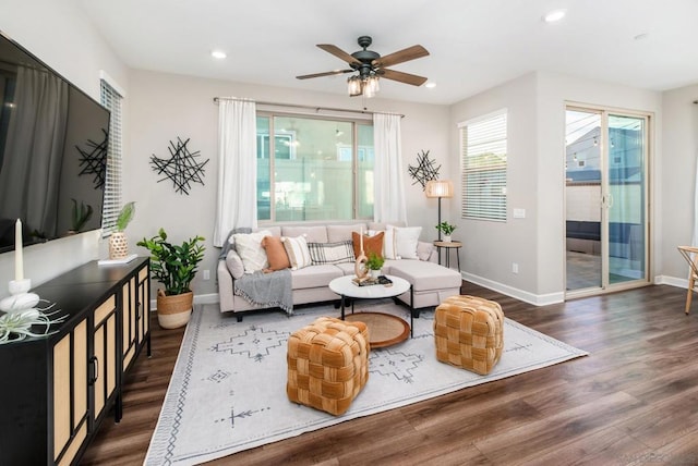 living room with dark hardwood / wood-style flooring and ceiling fan