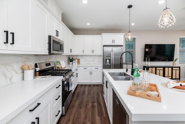 kitchen featuring pendant lighting, stainless steel appliances, sink, and white cabinets