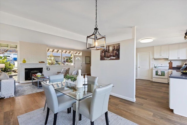 dining area featuring a brick fireplace and hardwood / wood-style floors