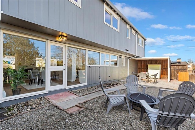 rear view of property with an outdoor fire pit and a patio