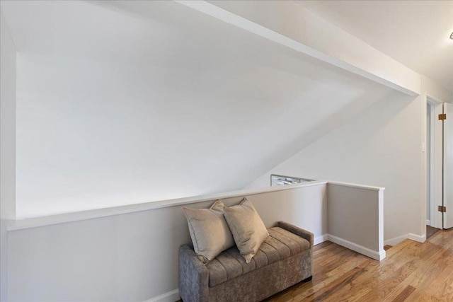 sitting room featuring lofted ceiling and light wood-type flooring