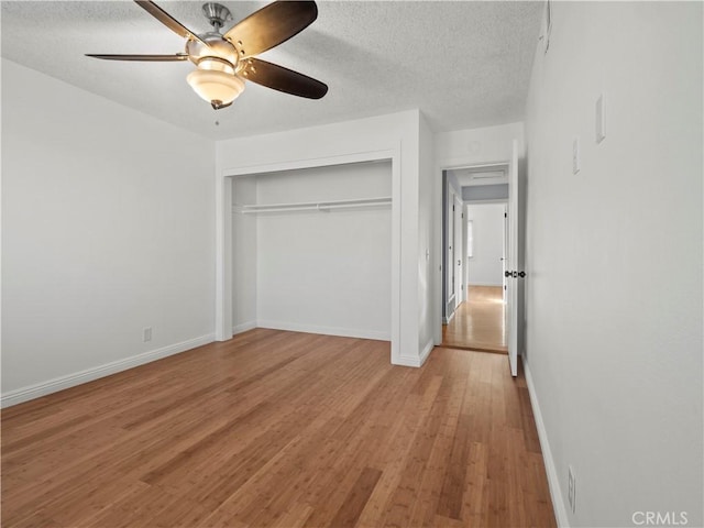 unfurnished bedroom featuring ceiling fan, light hardwood / wood-style floors, a closet, and a textured ceiling