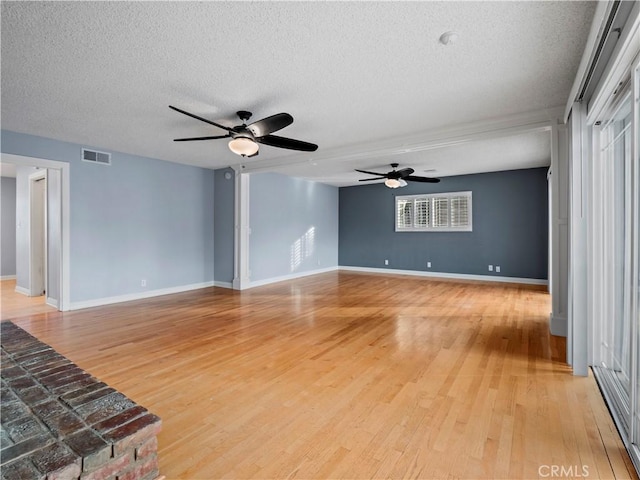 unfurnished living room with ceiling fan, light hardwood / wood-style flooring, and a textured ceiling