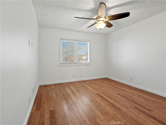 empty room with wood-type flooring, ceiling fan, and a textured ceiling