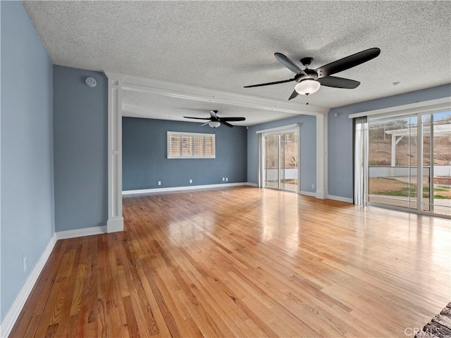 unfurnished room with a textured ceiling and light wood-type flooring