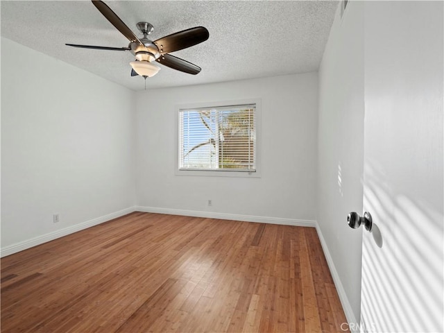 spare room featuring wood-type flooring, ceiling fan, and a textured ceiling