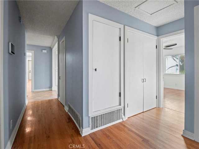 hallway featuring hardwood / wood-style floors and a textured ceiling