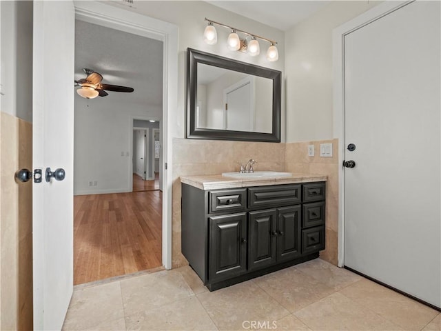 bathroom featuring vanity, ceiling fan, tile patterned floors, and tile walls