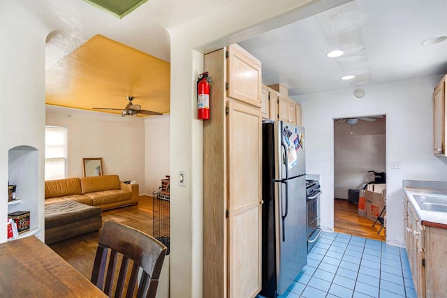 kitchen featuring light tile patterned flooring, stainless steel appliances, ceiling fan, and light brown cabinets