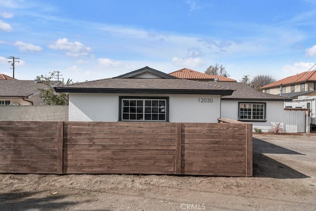 view of front of house with fence and stucco siding