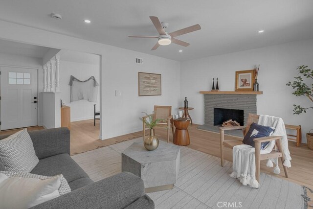 living room with light hardwood / wood-style flooring and ceiling fan