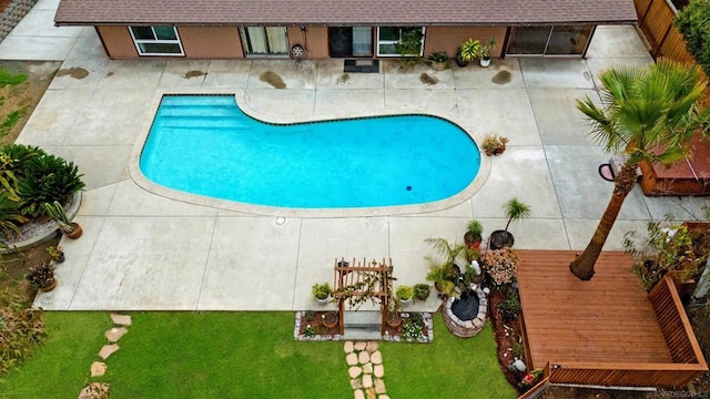 view of swimming pool with a patio and a yard