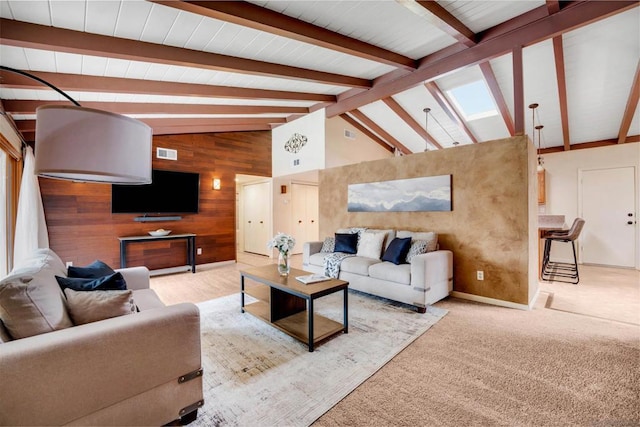 carpeted living room featuring beam ceiling, high vaulted ceiling, and wood walls