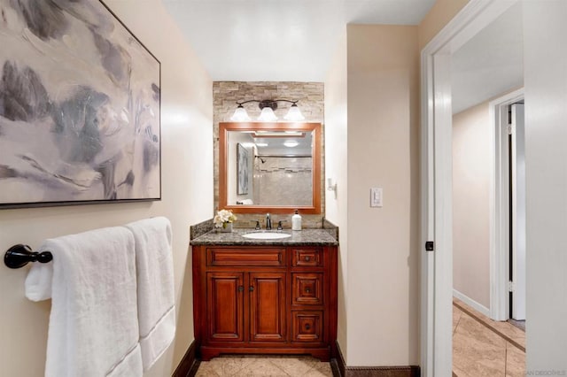 bathroom with walk in shower, vanity, and tile patterned flooring