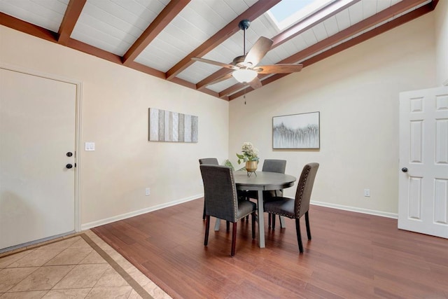 dining room featuring hardwood / wood-style flooring, ceiling fan, and lofted ceiling with skylight