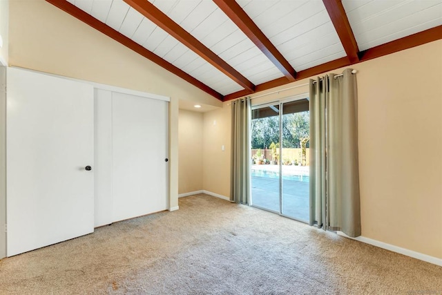 unfurnished bedroom featuring access to exterior, light colored carpet, vaulted ceiling with beams, and a closet