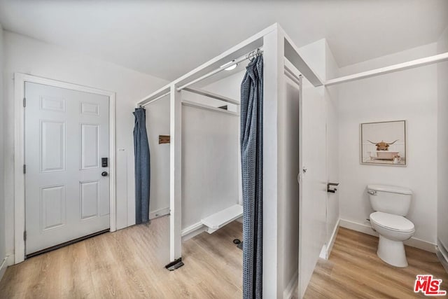 bathroom featuring wood-type flooring and toilet