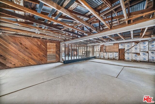 basement featuring wood walls