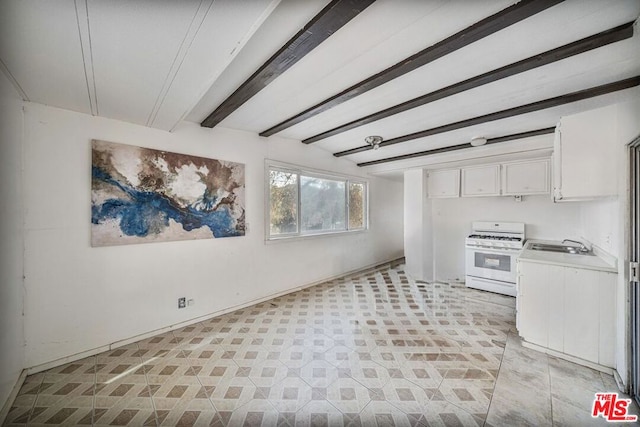 interior space with white cabinetry, white range with gas cooktop, sink, and beam ceiling