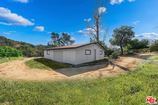 view of side of home featuring an outbuilding and a garage