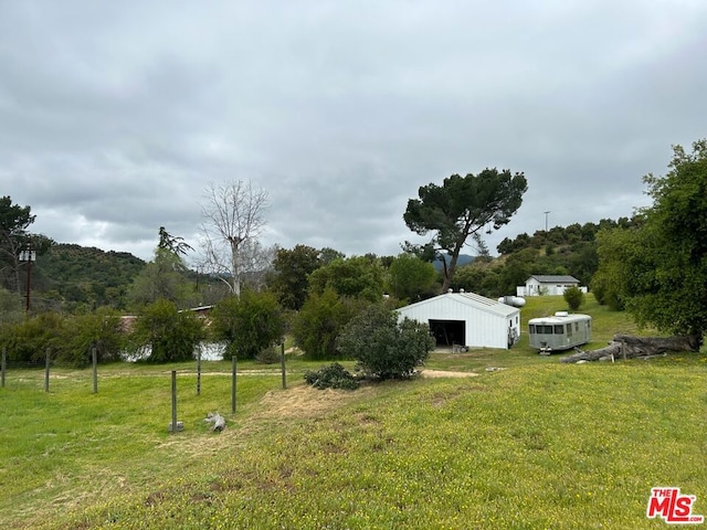 view of yard featuring an outdoor structure and a rural view