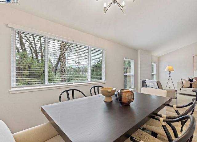 dining room with lofted ceiling and a notable chandelier