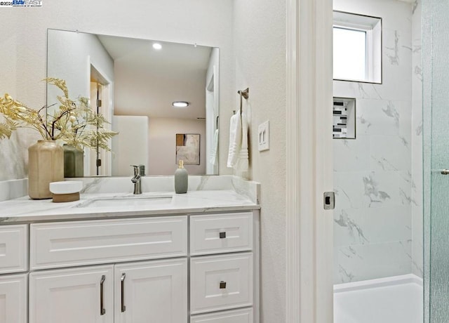 bathroom with vanity and tiled shower