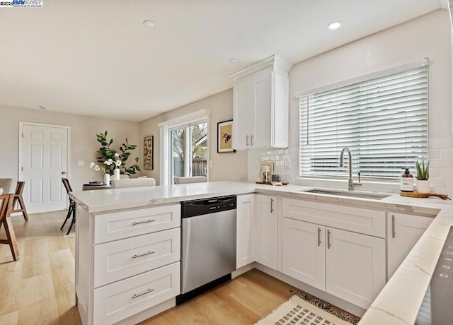 kitchen featuring sink, dishwasher, kitchen peninsula, light hardwood / wood-style floors, and white cabinets