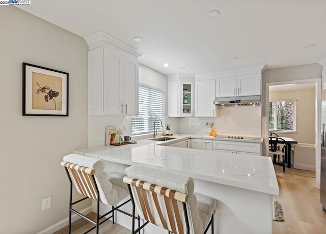 kitchen with white cabinetry, sink, and kitchen peninsula