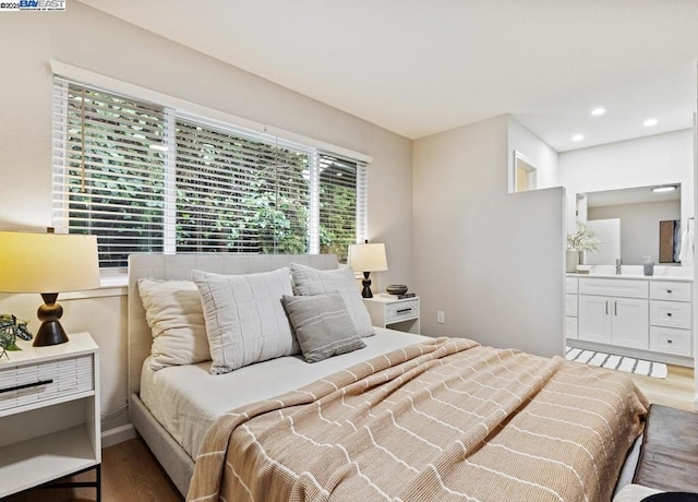 bedroom with wood-type flooring and connected bathroom