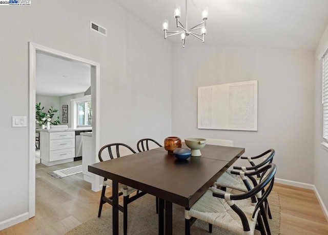 dining room with an inviting chandelier and light hardwood / wood-style flooring