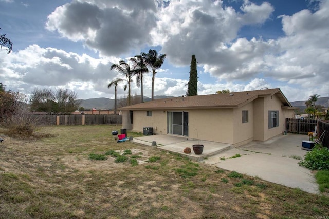 rear view of property with a patio, a mountain view, and central AC unit