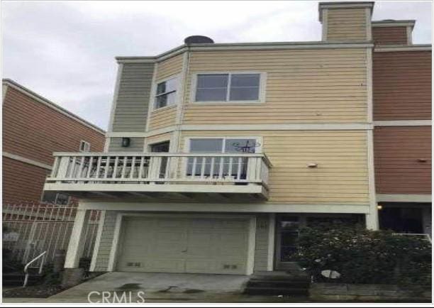 back of house featuring a balcony and a garage