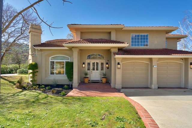 mediterranean / spanish-style home with a garage and a front lawn