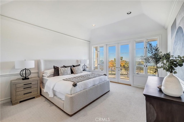 bedroom with access to exterior, vaulted ceiling, light colored carpet, and french doors