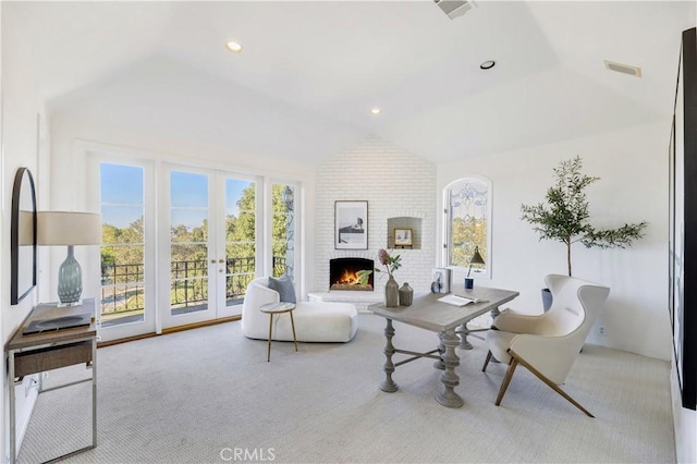 living room featuring light carpet, vaulted ceiling, a brick fireplace, and french doors