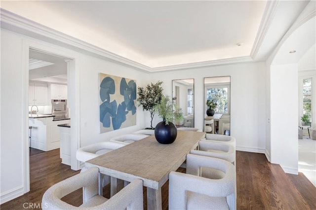 dining area featuring dark wood-type flooring, ornamental molding, and plenty of natural light