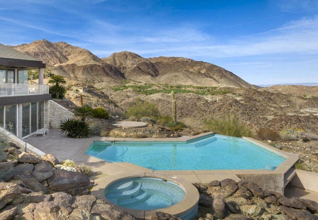 view of pool with a mountain view, a patio, and an in ground hot tub