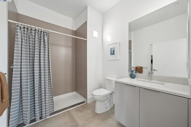 bathroom featuring vanity, tile patterned flooring, curtained shower, and toilet