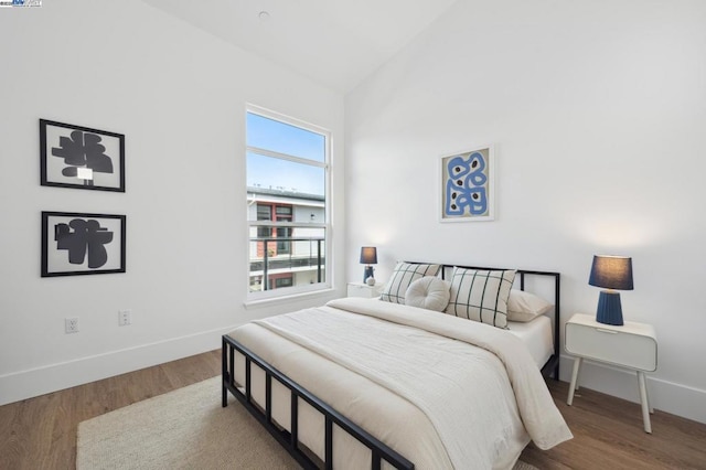 bedroom featuring wood-type flooring and vaulted ceiling