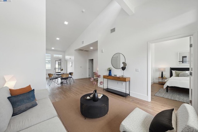 living room with high vaulted ceiling and light wood-type flooring