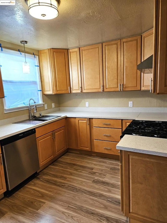 kitchen featuring dark hardwood / wood-style flooring, sink, decorative light fixtures, and dishwasher