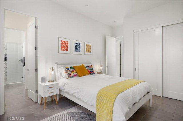 tiled bedroom featuring ensuite bathroom and a closet