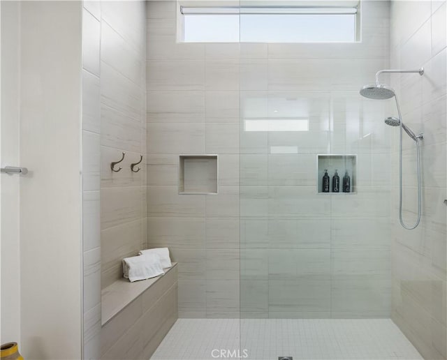 bathroom featuring a wealth of natural light and tiled shower