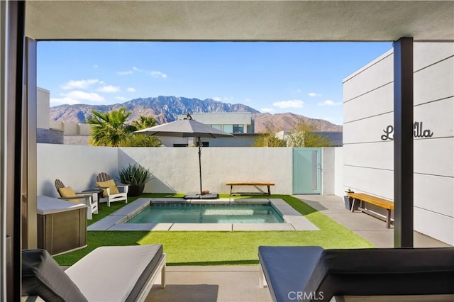 view of pool with a mountain view, a yard, and a patio area