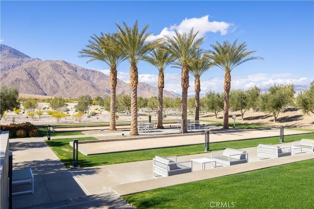 view of community with a mountain view and a lawn