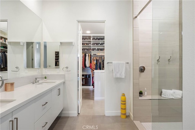 bathroom featuring vanity, tile patterned floors, and a tile shower